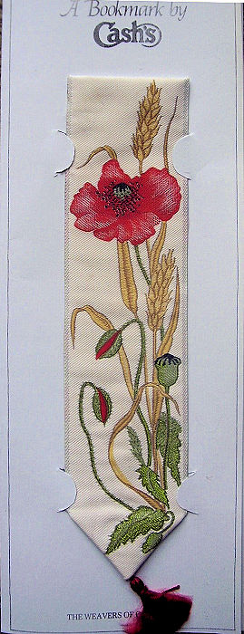 J & J Cash woven bookmark, with no words, but images of a poppy, buds and seed pod