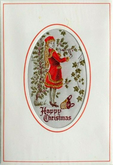 J & J Cash woven Christmas card, with HAPPY CHRISTMAS words, and image of woman decorating with holly & ivy