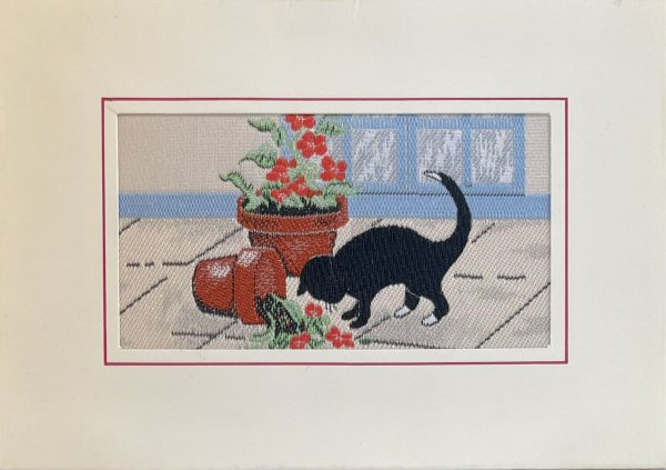 J & J Cash woven card, with no words, but picture of a Black Cat stood next to an up-turned flower pot