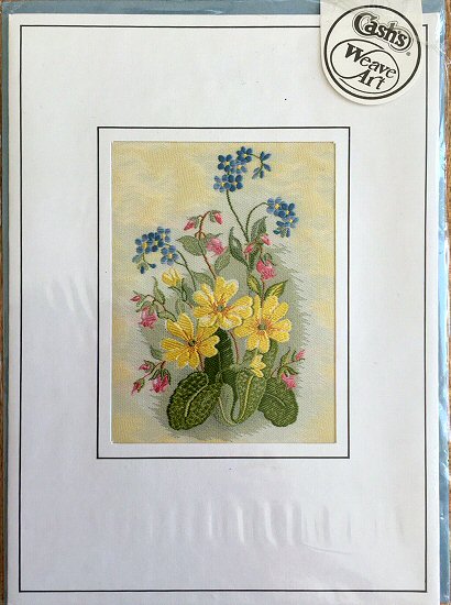 J & J Cash woven flower card, with image of three primrose with blue & pink flowers