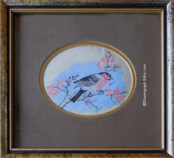 Framed woven picture of a bullfinch, perched on a branch