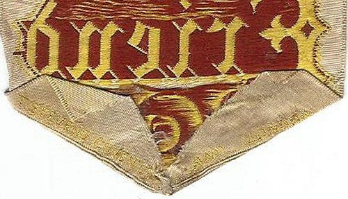 image of reverse pointed end with indistinct gold woven words