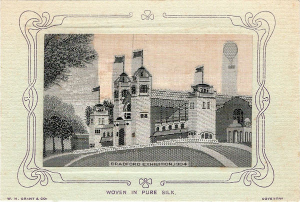 Black and white silk image of Exhibition building, with flags on flagpoles and hot-air balloon in top right hand corner