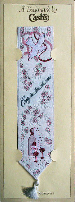J & J Cash woven bookmark, with title words and image of a champagne bottle, trimmed in ruby