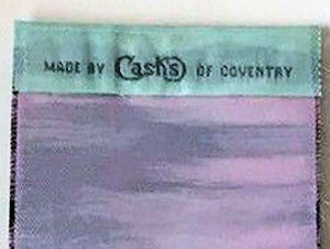 J & J Cash woven logo on the reverse top turnover of this bookmark