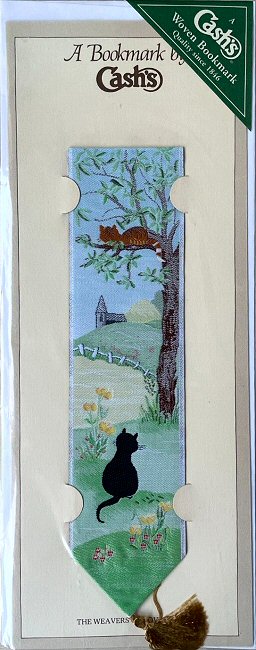 J & J Cash woven bookmark, with no words, and images of a sitting black cat, with a brown cat in a tree