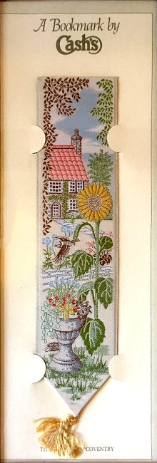 J & J Cash woven bookmark, with no words, but images of a sunflower with a cottage in the background