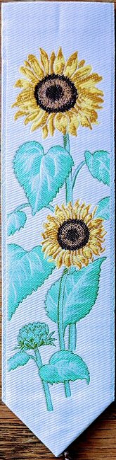 J & J Cash woven bookmark, with no words, but images of two sunflowers with a blue background