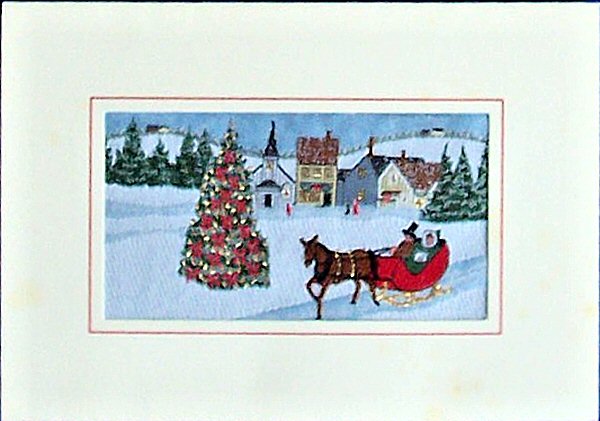 J & J Cash woven Christmas card, with no words, with image of a decorated Christmas tree, village in the background, and an horse drawn sleigh with two people