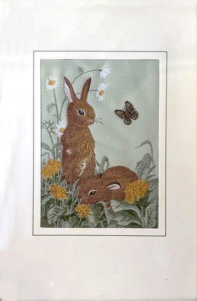 J & J Cash woven card, with no words, but picture of a pair of rabbits and a butterfly