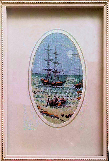 J & J Cash small oval centred woven picture with image of smugglers or sailors on a beach with a sail boat in the background
