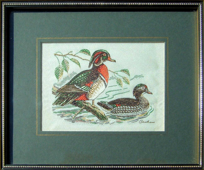 J & J Cash woven picture of a bird, with no words, but image of two Wood Ducks