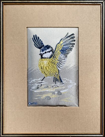 J & J Cash woven picture of a bird, with no words, but image of a Blue tit stood in water