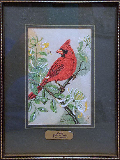 J & J Cash woven picture of a bird, with no words, but image of a Cardinal