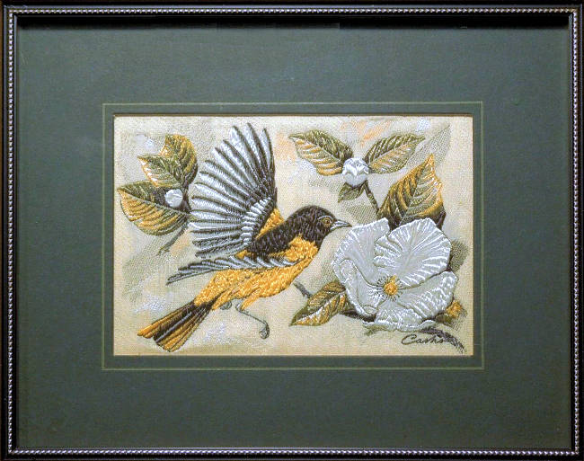 J & J Cash woven picture of a bird, with no words, but image of an Oriole