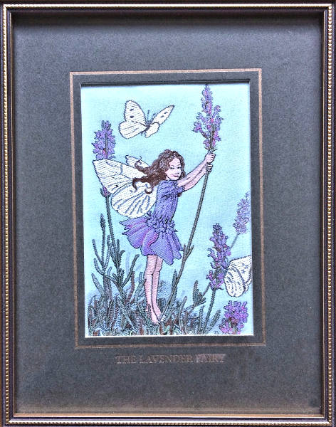 J & J Cash woven picture with THE LAVENDER FAIRY title words, and image of a lavender coloured fairy with butterfly, flowers and leaves