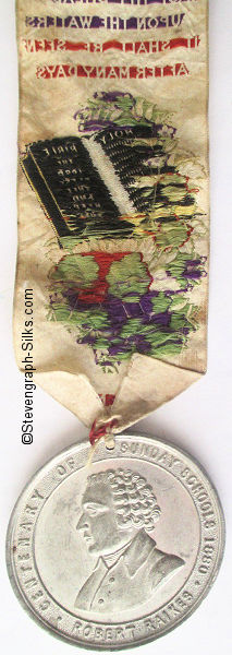 ribbon with words, image of bible and medal attached at pointed end
