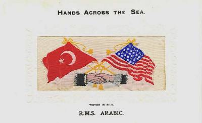 image of shaking hands, flags and tassles